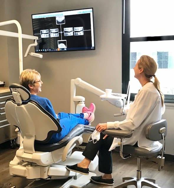 At our Tulsa-based holistic dental practice, a biological dentist collaborates with their patient to review X-rays on-screen, emphasizing comprehensive care that prioritizes overall well-being and health.
